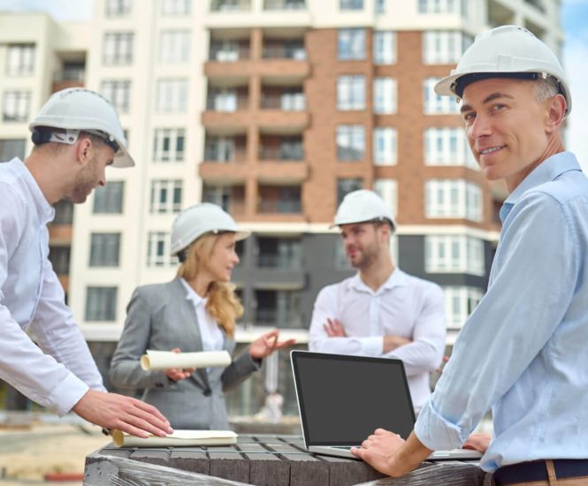 Worker Standing Among His Three Coworkers Construction Site